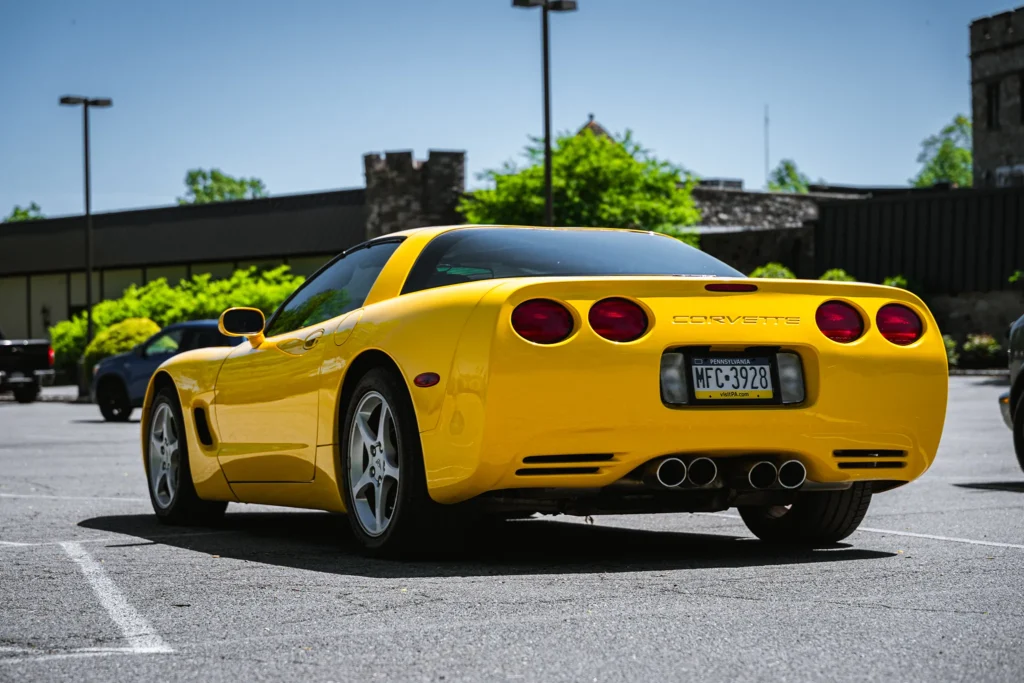 A photo of a yellow Corvette from behind