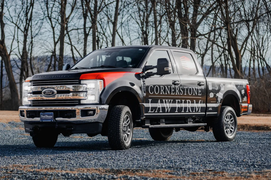 A photo of a black truck with a Cornerstone Law Firm wrap from the front