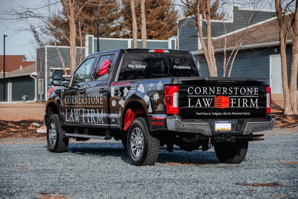 A photo of a black truck with a Cornerstone Law Firm wrap from the back