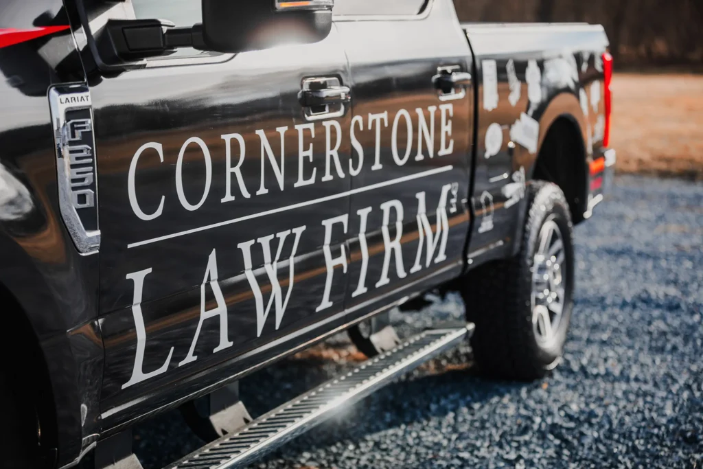 A close up of a black truck with a Cornerstone Law Firm wrap from the side