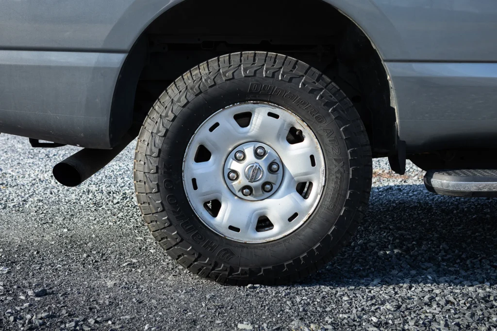 A photo of a gray truck's back tire