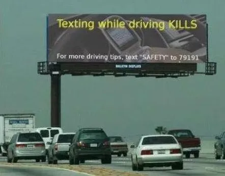 A billboard that says "Texting while driving KILLS. For more driving tips, text "SAFETY" to 79191"
